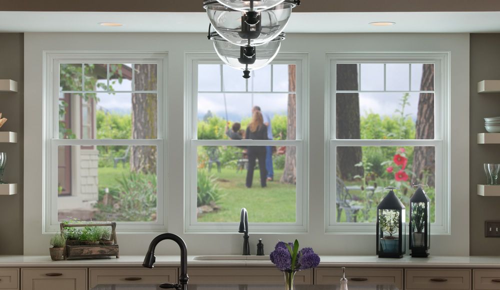 View through kitchen window of a person standing outside in the garden.