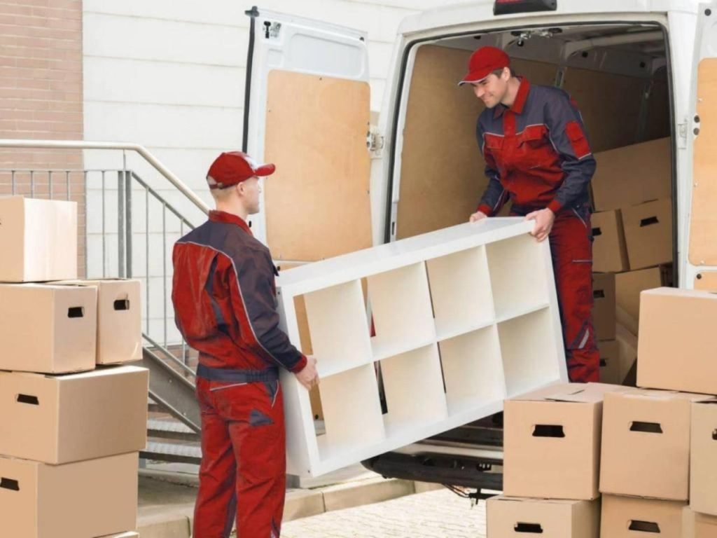 Movers loading van with furniture and boxes.